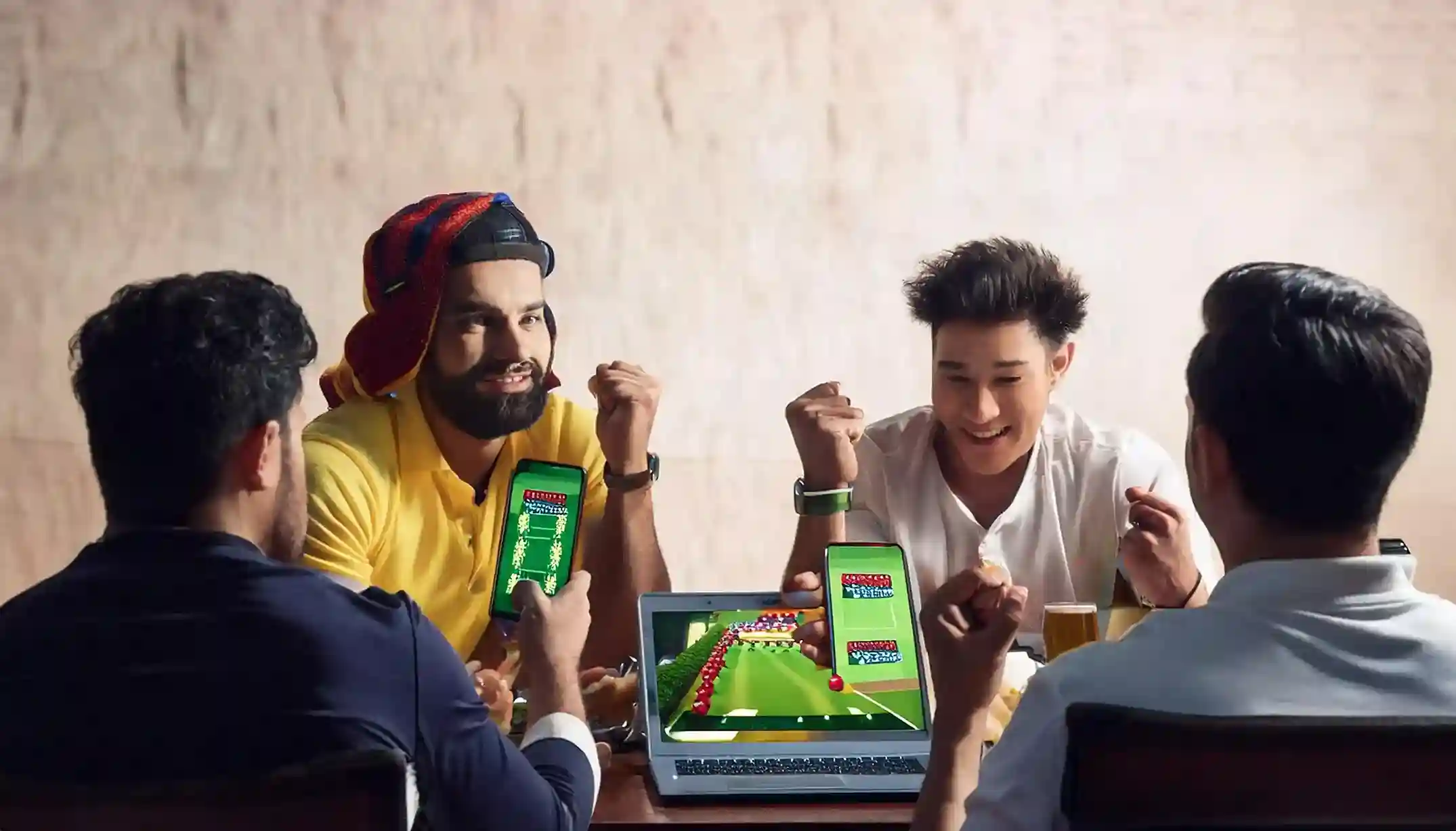 Four friends cheering around phones and a laptop streaming live cricket via Reddybook